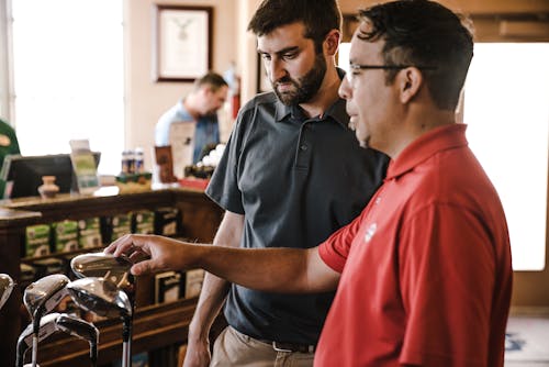 Dwóch Mężczyzn Stojących W Pobliżu Klubów Golfowych