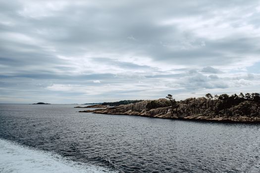 Moody overcast seascape with rugged rocky shoreline, perfect for nature enthusiasts.