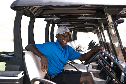 Free Man Sitting on Black and Gray Golf Cart Stock Photo