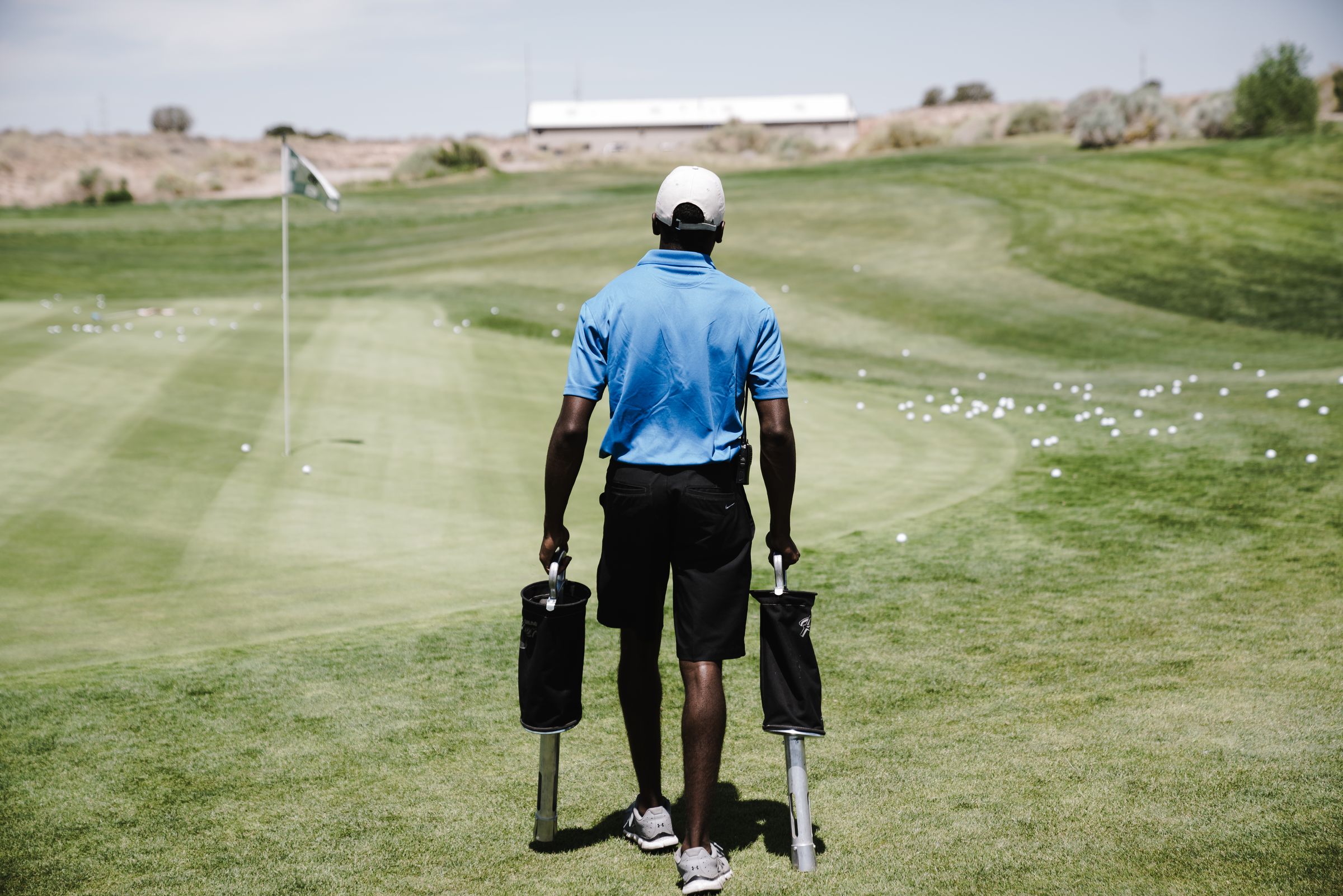 Golfer teeing off on a sunny golf course fairway