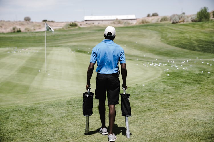 Man In Blue Polo Shirt Carrying Black Bags