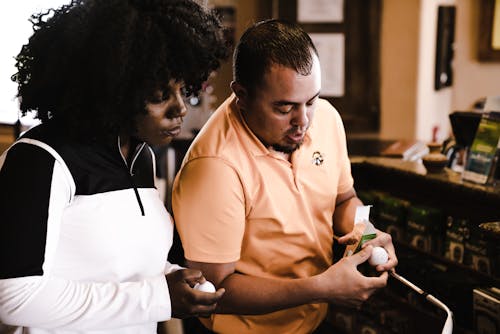 Free Woman and Man Looking at Golf Balls Stock Photo