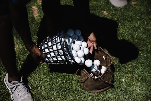 Free Person Pouring Golf Balls in Brown Leather Bag Stock Photo