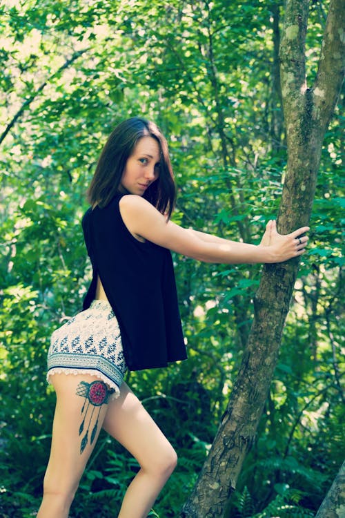 A Young Woman Holding a Tree Trunk