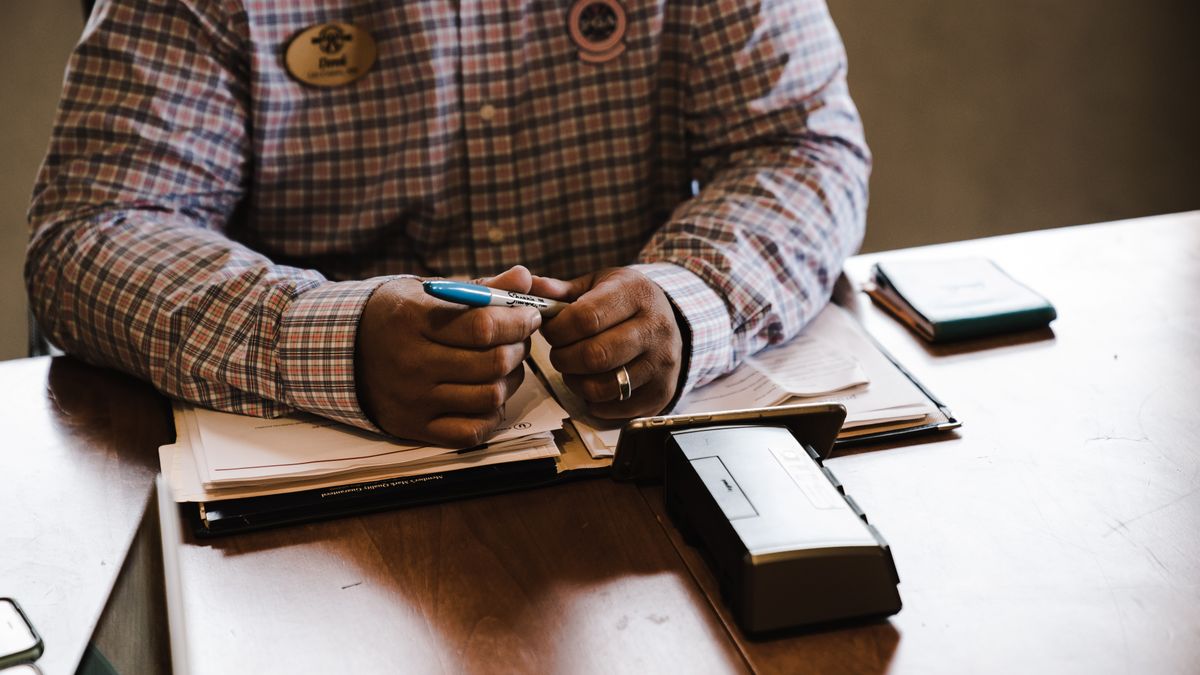 A businessman with documents, organizing and working at his desk for an office task.