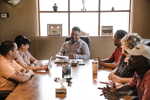 Free People Sitting Around Wooden Table  Stock Photo