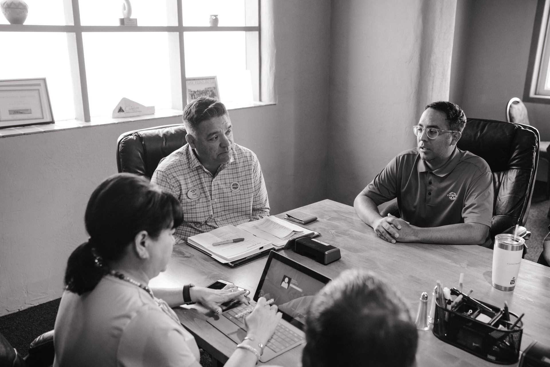 Professional business meeting with diverse colleagues collaborating at a table indoors.