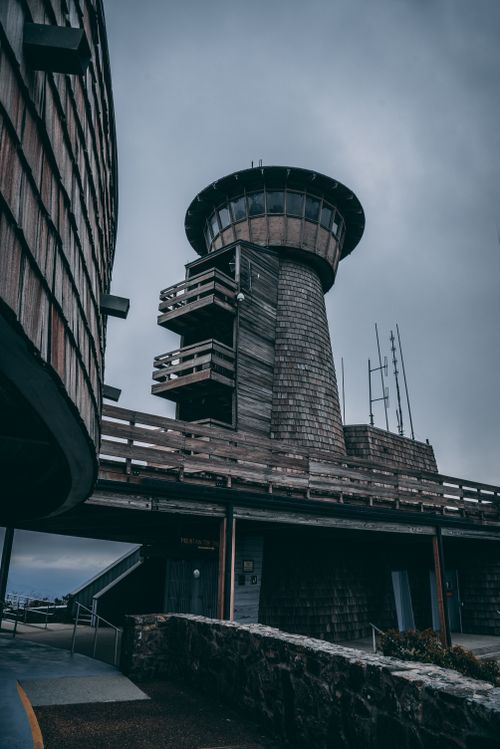 Free A low angle shot of a historic lighthouse tower set against a dramatic cloudy sky. Stock Photo