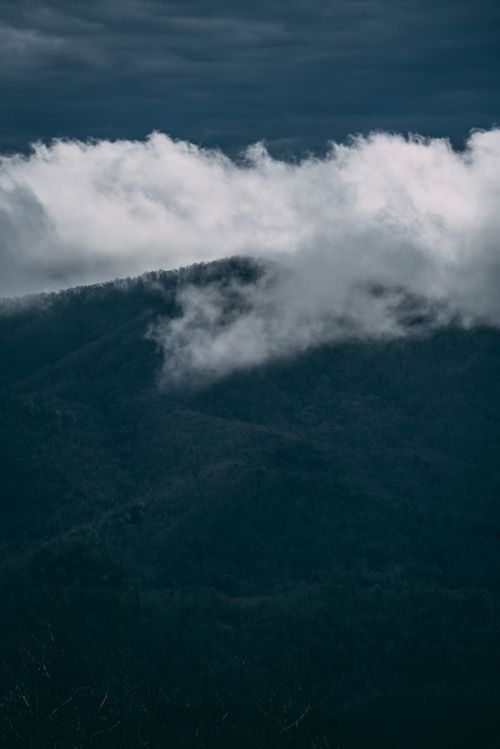Free Dramatic view of mist-covered mountains under cloudy skies. Stock Photo