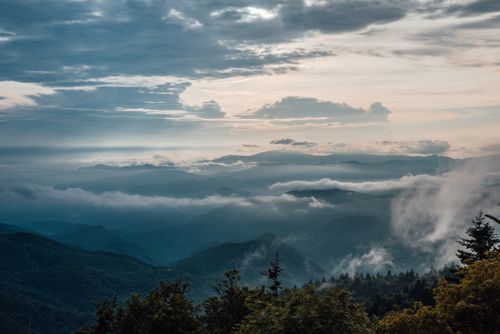 Free A breathtaking view of a mountain range shrouded in clouds and mist, creating a serene atmosphere. Stock Photo
