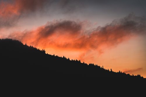 Free A breathtaking view of a mountain silhouette against an orange sky during sunset. Stock Photo