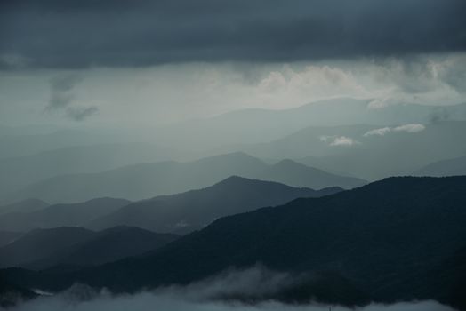 Majestic mountain range with moody overcast skies, creating a dramatic landscape view.