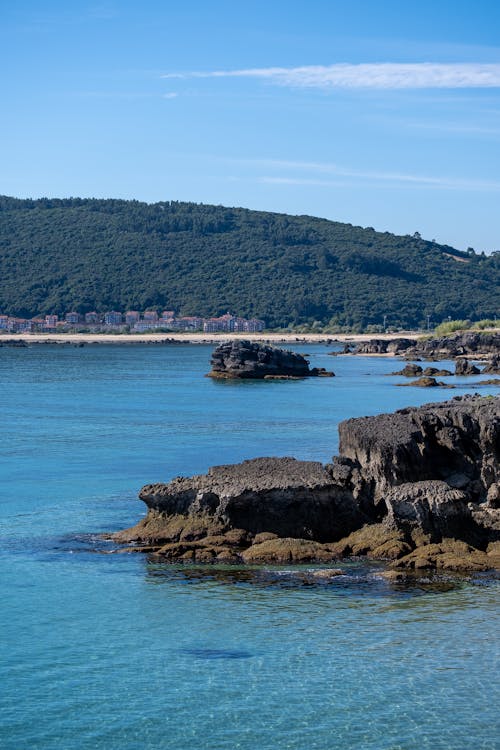 View of a Rocky Shore and a Hill in the Horizon 