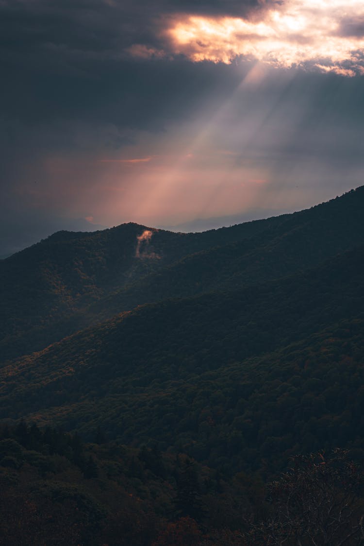 Mountains In Sunlight Shining Between Storm Clouds