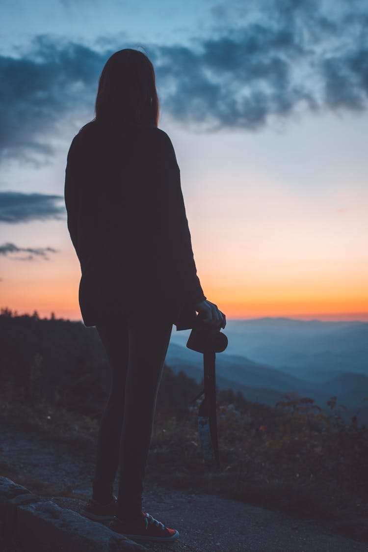 Woman Looking At Sunset In Mountains