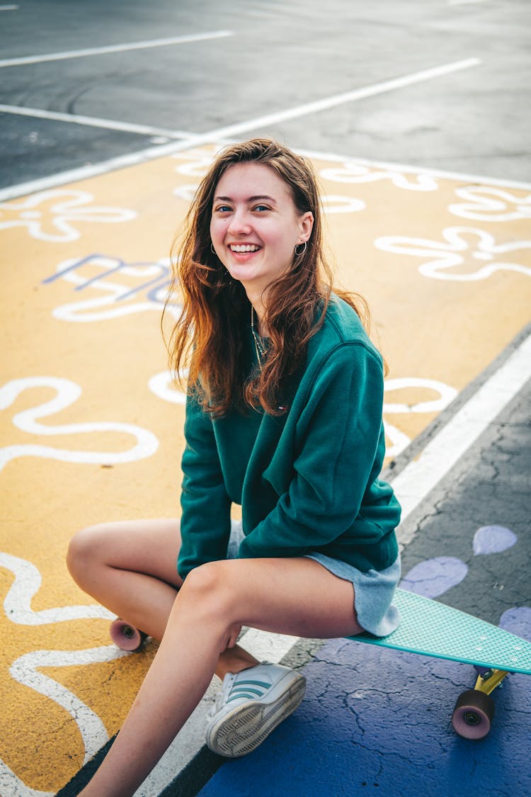 A Woman Sitting On A Penny Board