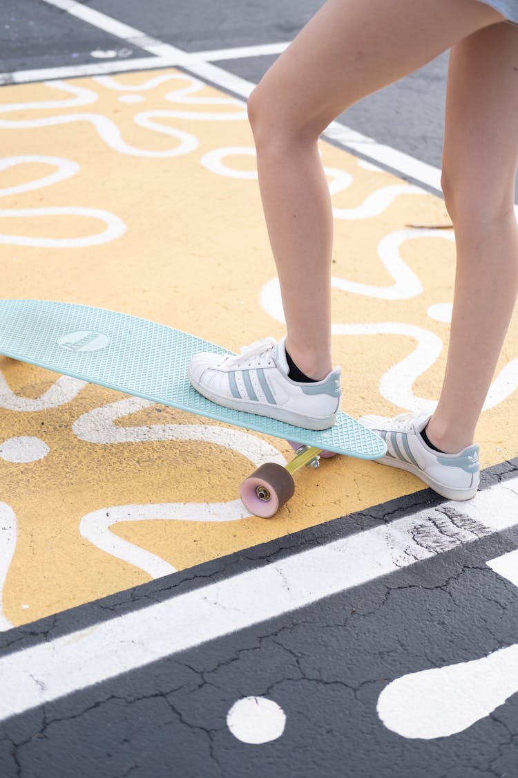 A Woman Stepping On A Penny Board