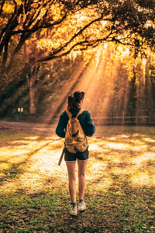 A Woman Standing on Brown Grass Field