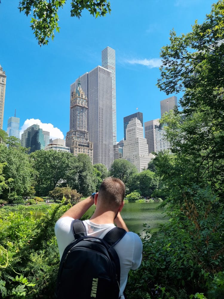 Man With Black Backpack Near Green Trees