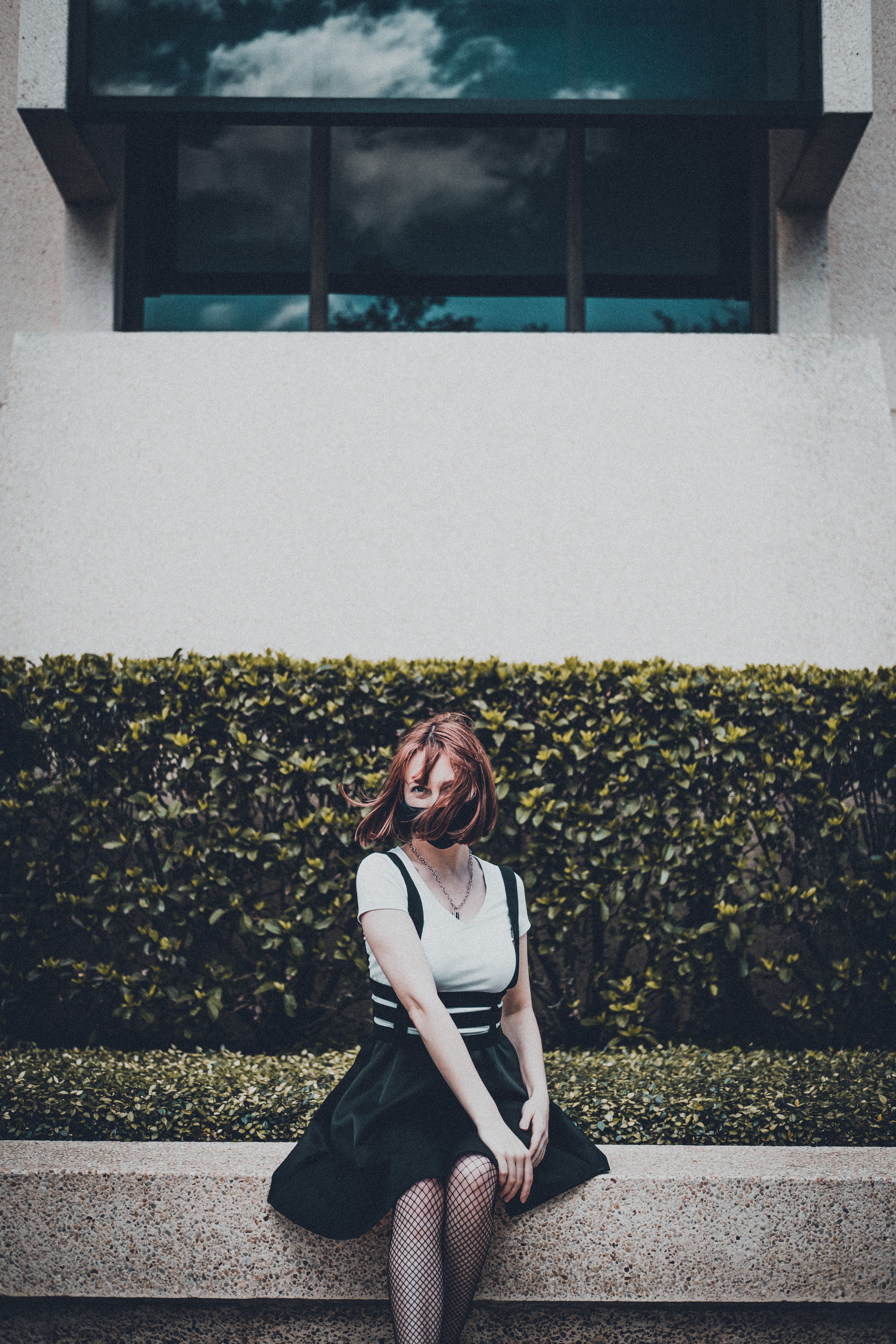 Young Woman Kneeling in an Urban Park Setting · Free Stock Photo