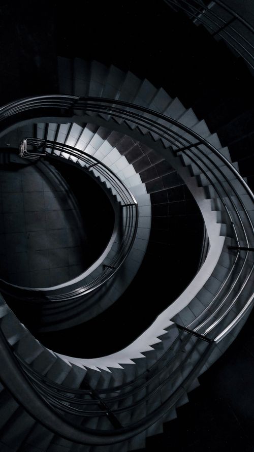 Free Artistic high angle view of a dramatic spiral staircase in monochrome tones. Stock Photo