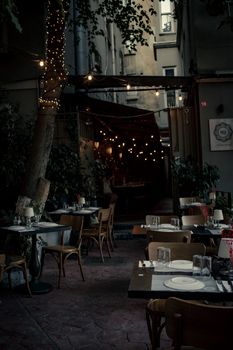 Outdoor dining area with string lights creating a cozy ambiance at night.