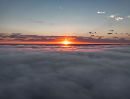 A breathtaking aerial view of a sunset above clouds in Weaver, MN, USA.