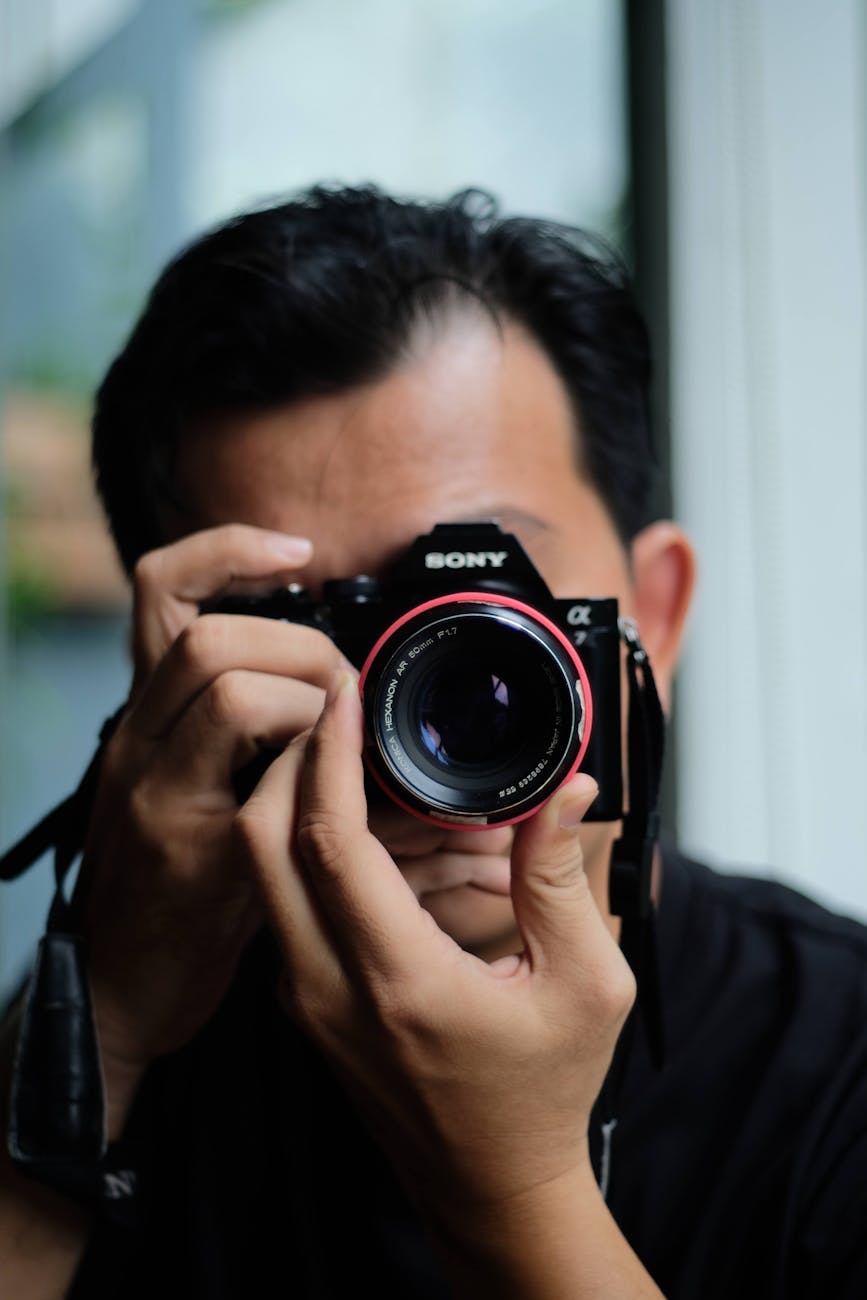Close-up of a photographer capturing a moment with a camera.