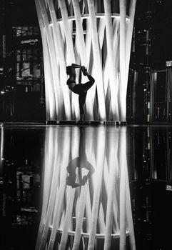 Backlit silhouette of a dancer posing in modern architecture, New York