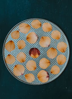 Top view of rose petals artistically arranged on a metal tray, creating an elegant flat lay image.