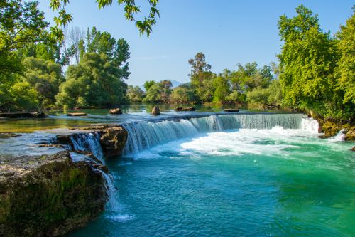 Free A vibrant waterfall in a lush forest with turquoise water, perfect for nature enthusiasts. Stock Photo