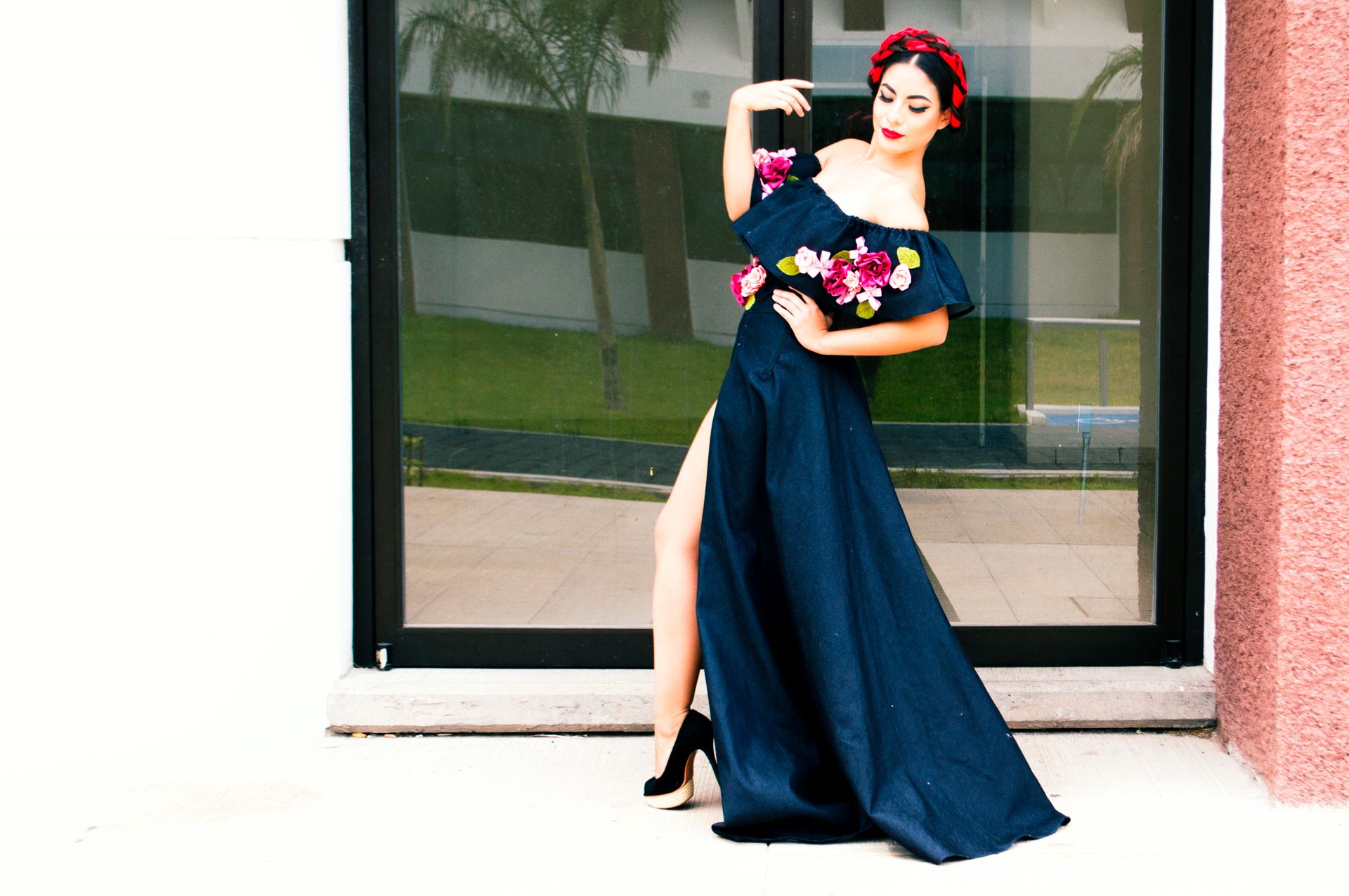 Elegant woman in a floral gown posing outdoors in Morelia, showcasing fashion and style.