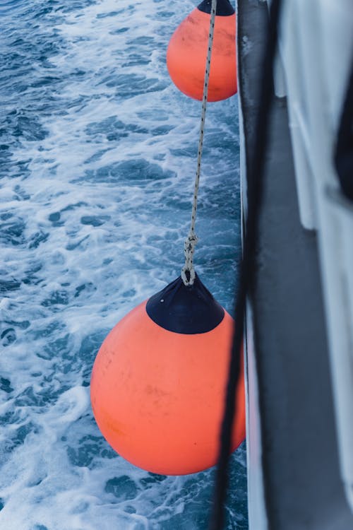 An Orange Fender Hanging from the Side of a Boat