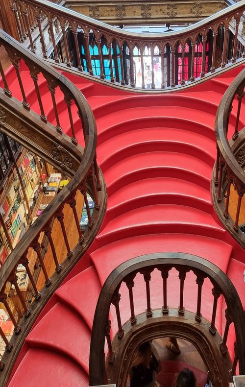Free High-angle view of the famous red staircase at Lello Bookstore in Porto, Portugal, with intricate wooden handrails. Stock Photo