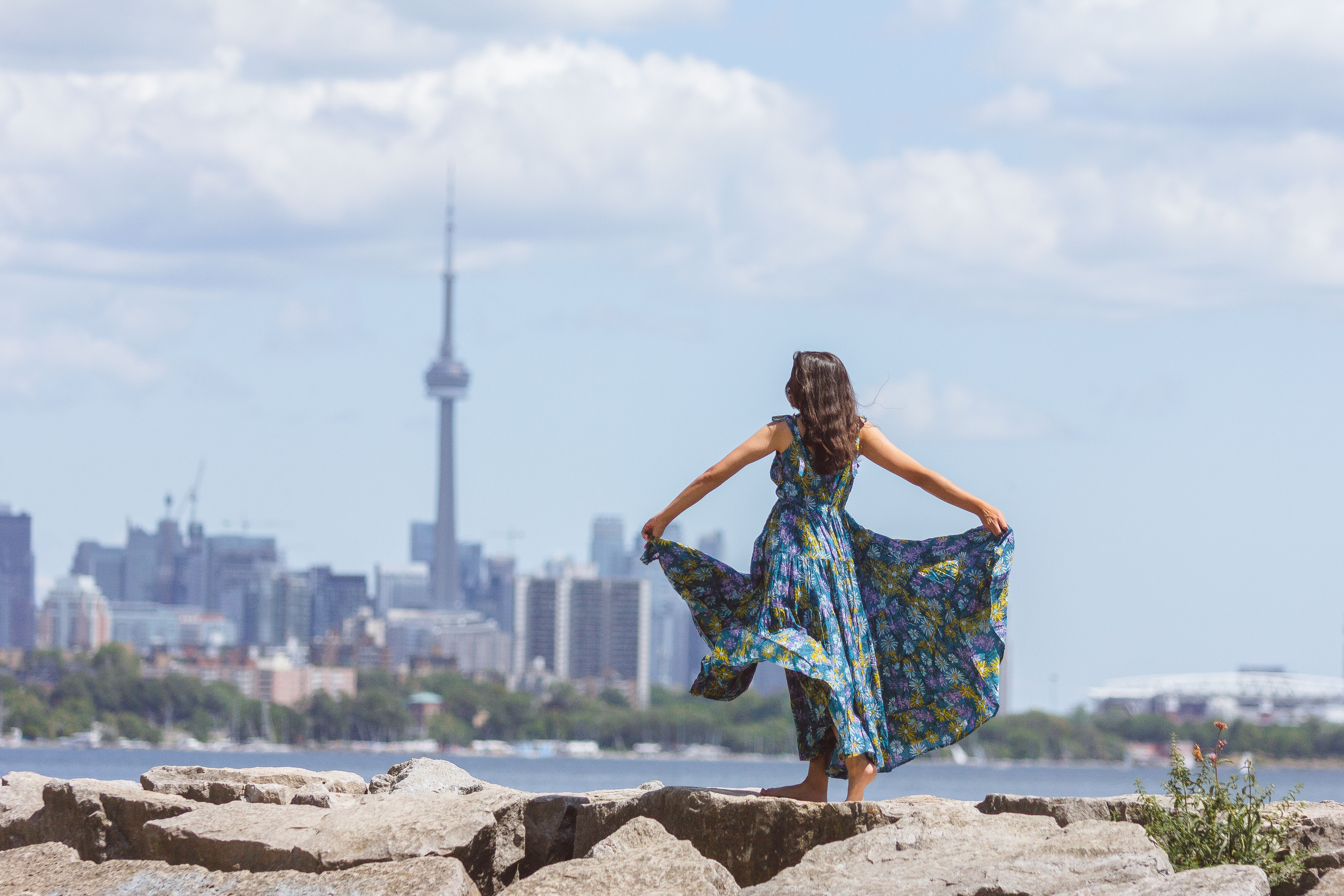 Woman Holding Her Floral Dress Standing on Rock · Free Stock Photo