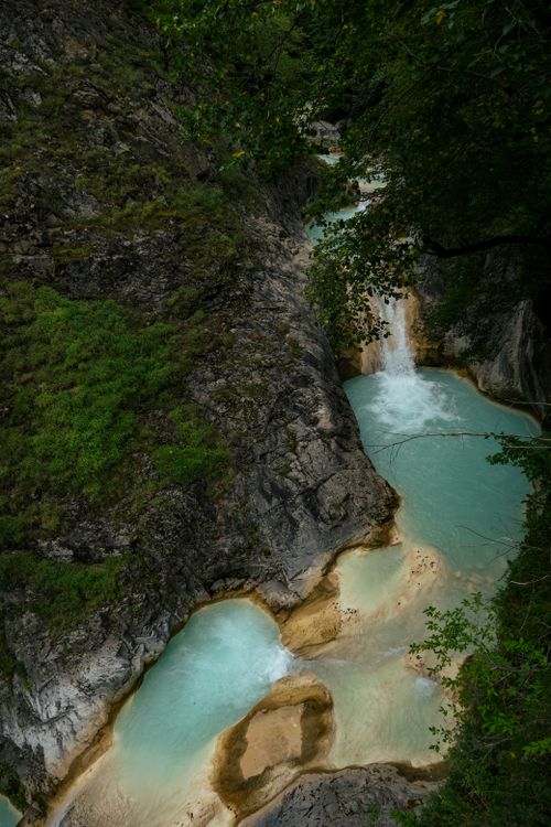 Free Breathtaking aerial perspective of a waterfall cascading into vibrant turquoise pools in a lush landscape. Stock Photo