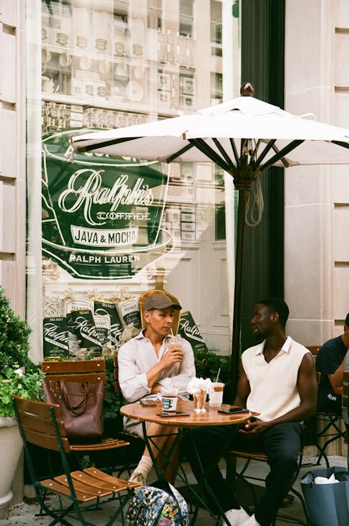 Men Sitting Outside a Coffee Shop Having a Conversation