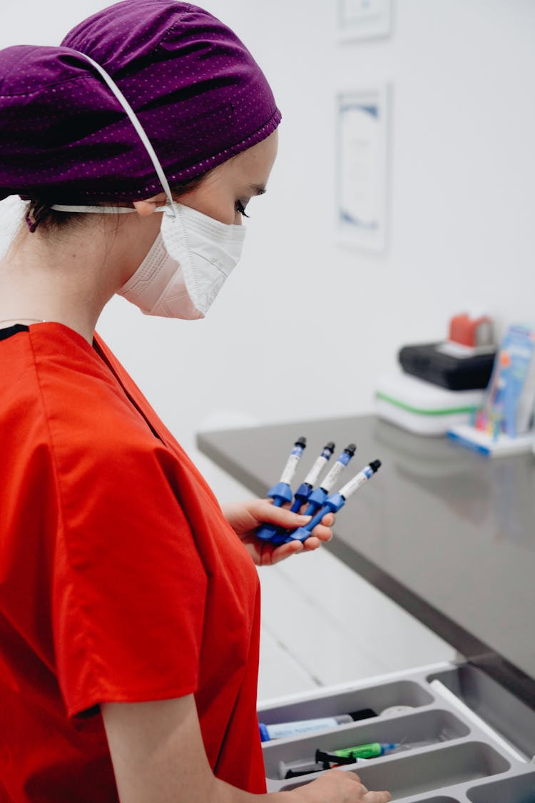 Nurse Holding Medical Instruments In A Dentist Office 