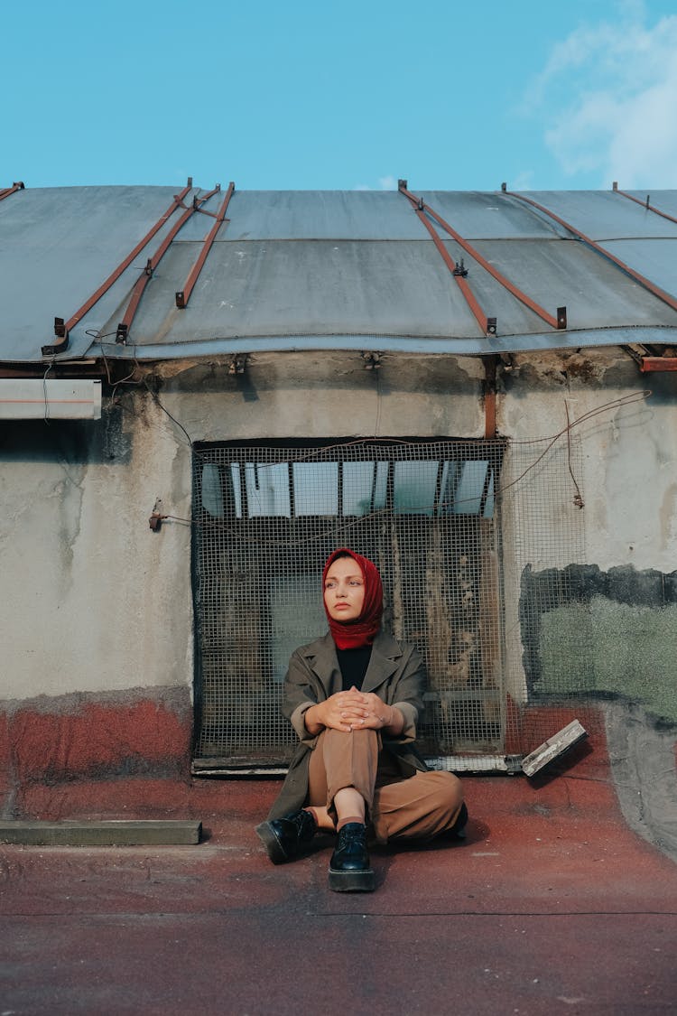 Woman In Hijab Sitting On Building Roof