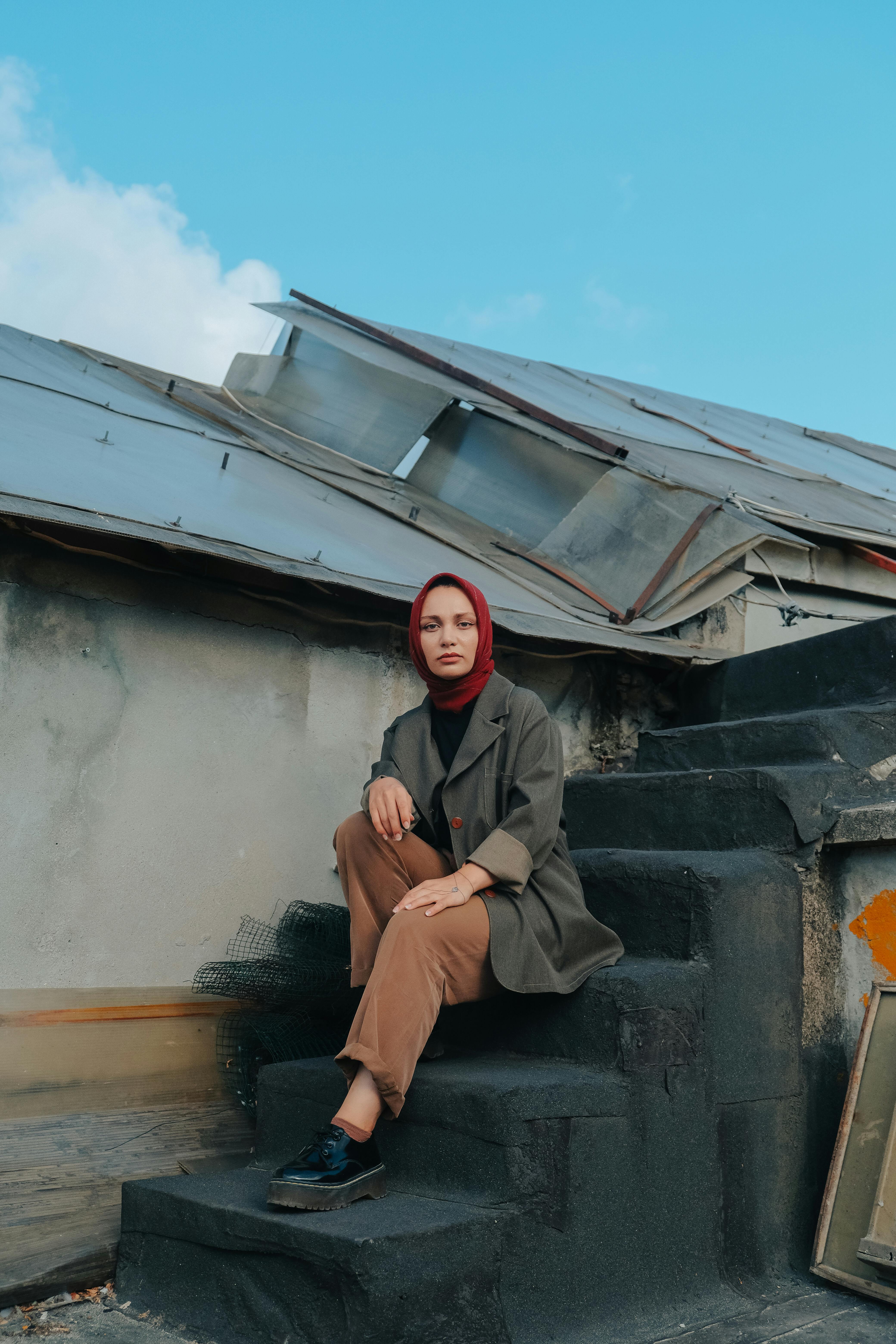 woman in hijab sitting on stairs on rooftop