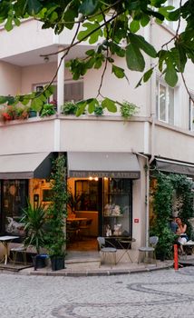 Coin de café extérieur confortable avec des plantes et un chemin en pavés, offrant une expérience de repas conviviale.