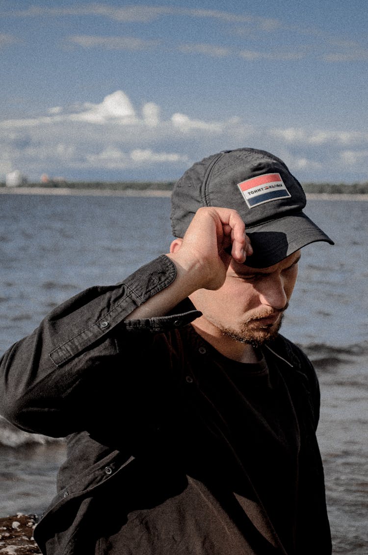 Man In Baseball Cap On Sea Background