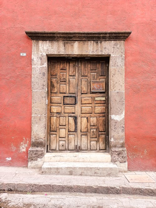 Brown Wooden Door on Red Concrete Wall