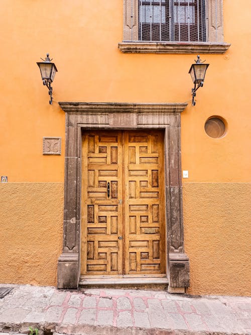 Brown Wooden Door on Brown Concrete Building