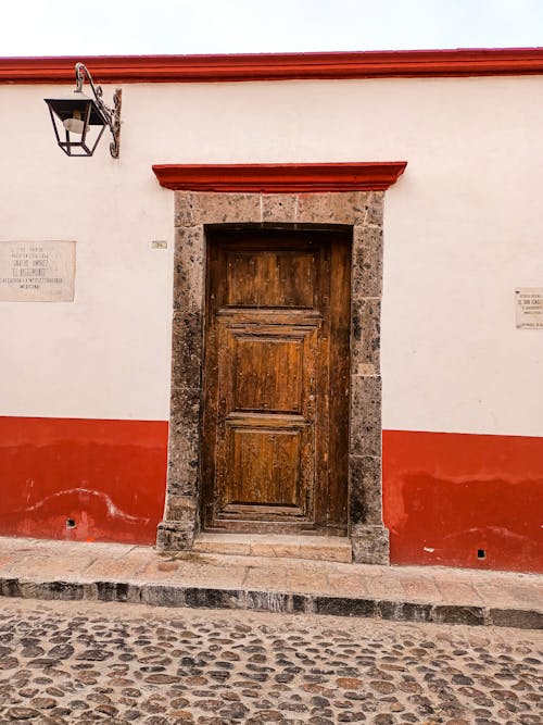 Free Old Wooden Door on White Concrete Wall Stock Photo