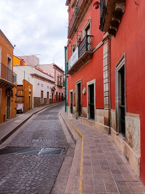 Free Colorful alleyway in Guanajuato showcasing traditional Mexican architecture with empty street and vibrant buildings. Stock Photo