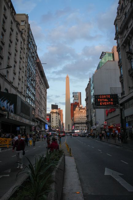 Discover the bustling atmosphere around the Obelisco de Buenos Aires, a city landmark, during the vibrant evening.