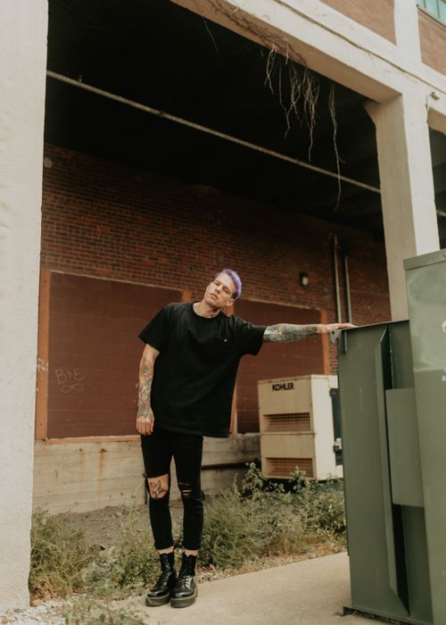 Free Stylish man with dyed hair and tattoos standing in a urban area in Des Moines, IA. Stock Photo