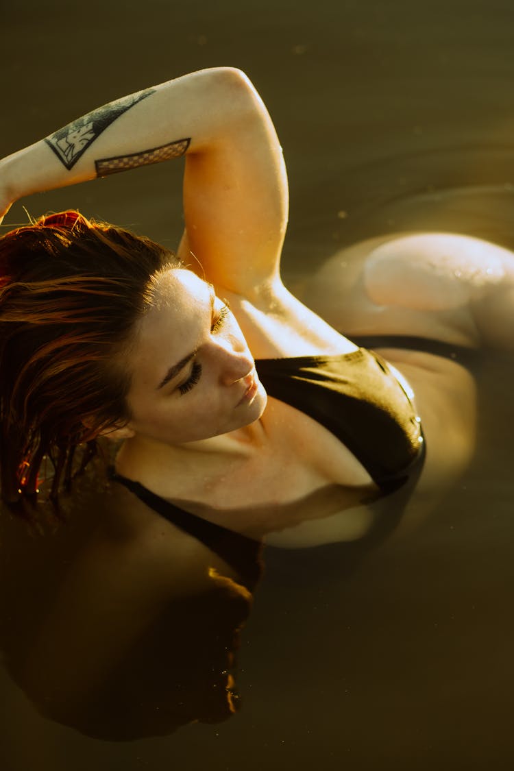 Woman With Tattoos Posing In Water