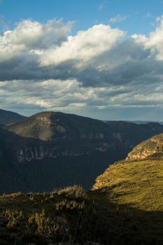 A stunning aerial view of a mountain valley under cloudy skies, showcasing nature's beauty.
